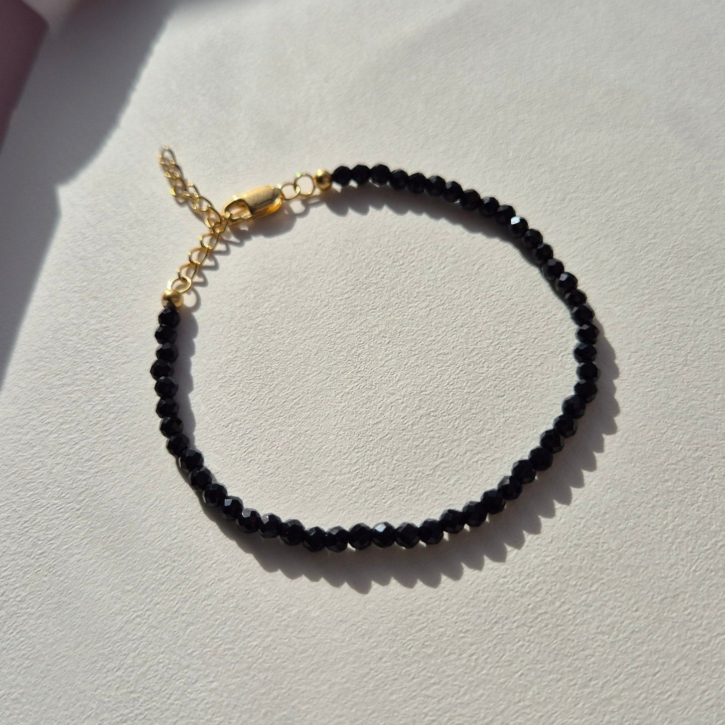 Armband med facetterade onyx kristaller och justerbart lås av guldförgyllt silver