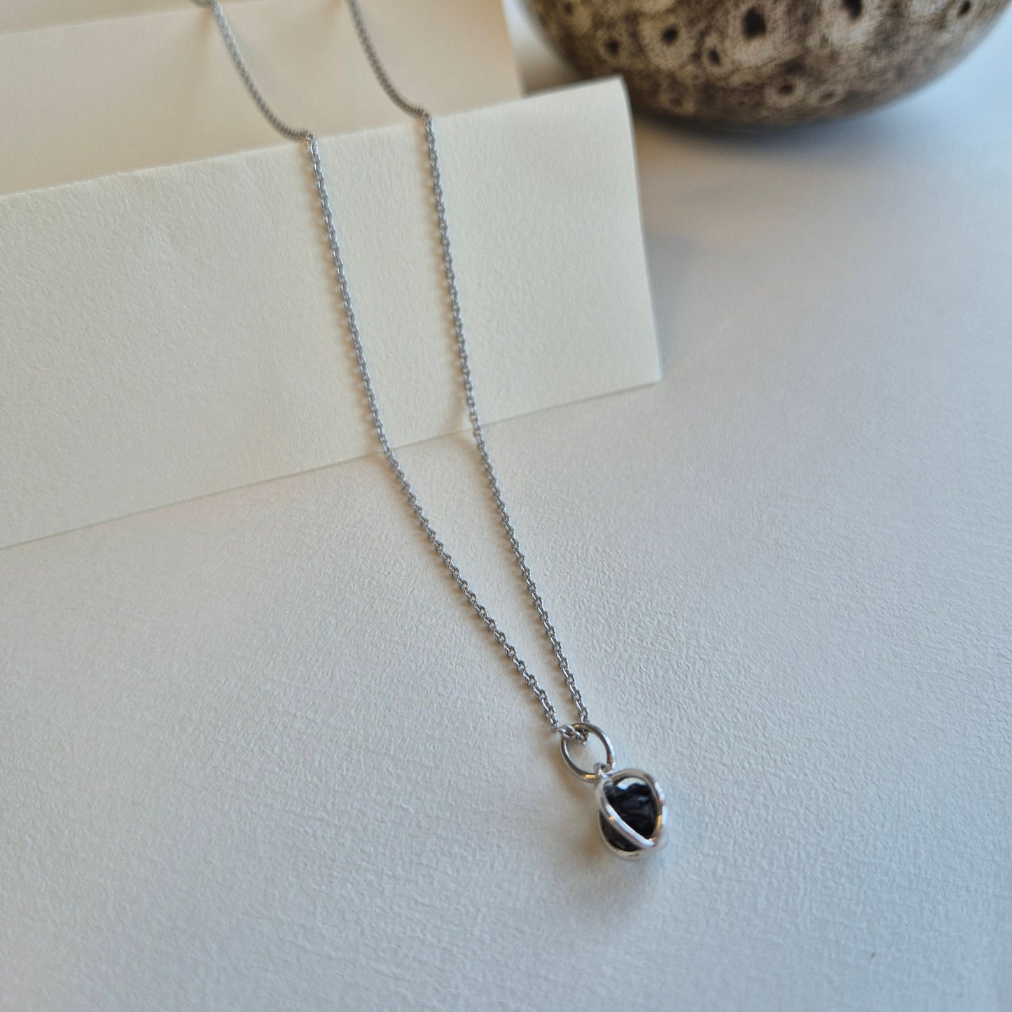 Hängsmycke av silver med rå kristall av onyx
