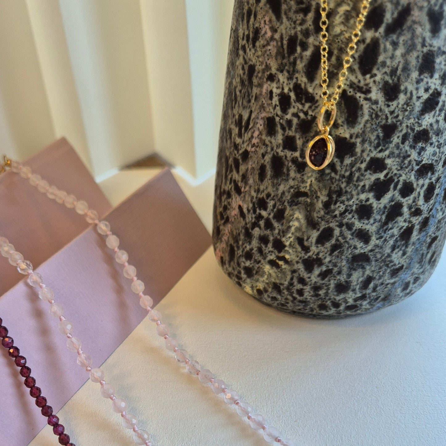 Kombination av armband och halsband med facetterade kristaller av rosenkvarts och granat med justerbart lås av guldförgyllt silver