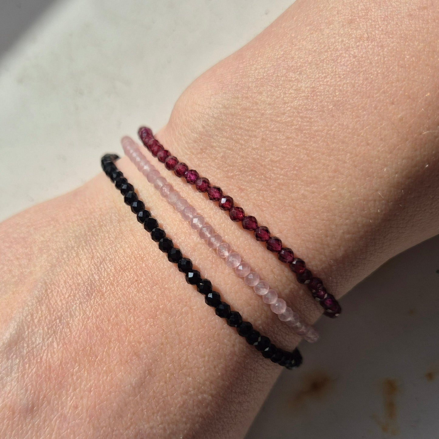 Kombination av armband med facetterade kristaller av onyx rosenkvarts och granat med justerbart lås av guldförgyllt silver