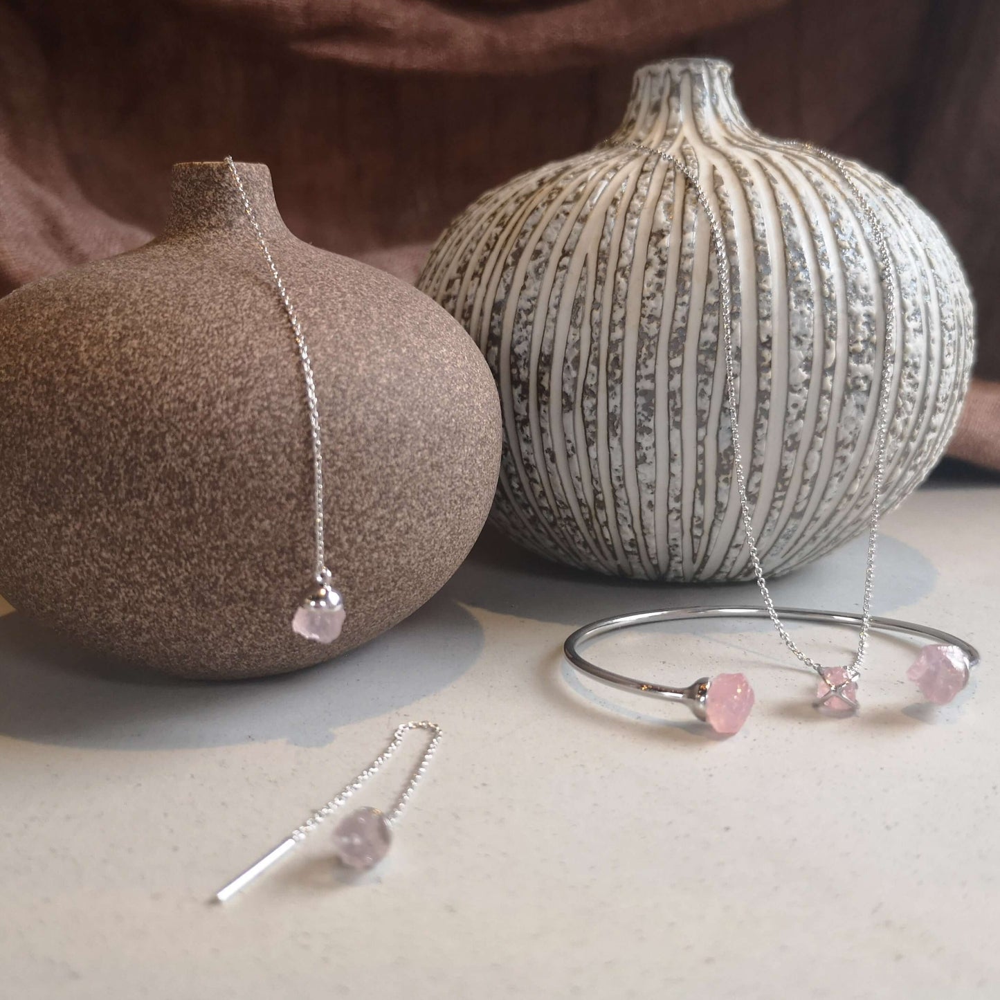 Smycken av äkta silver och rå kristall av rosenkvarts. halsband, armring, armband, örhängen och hängsmycke.